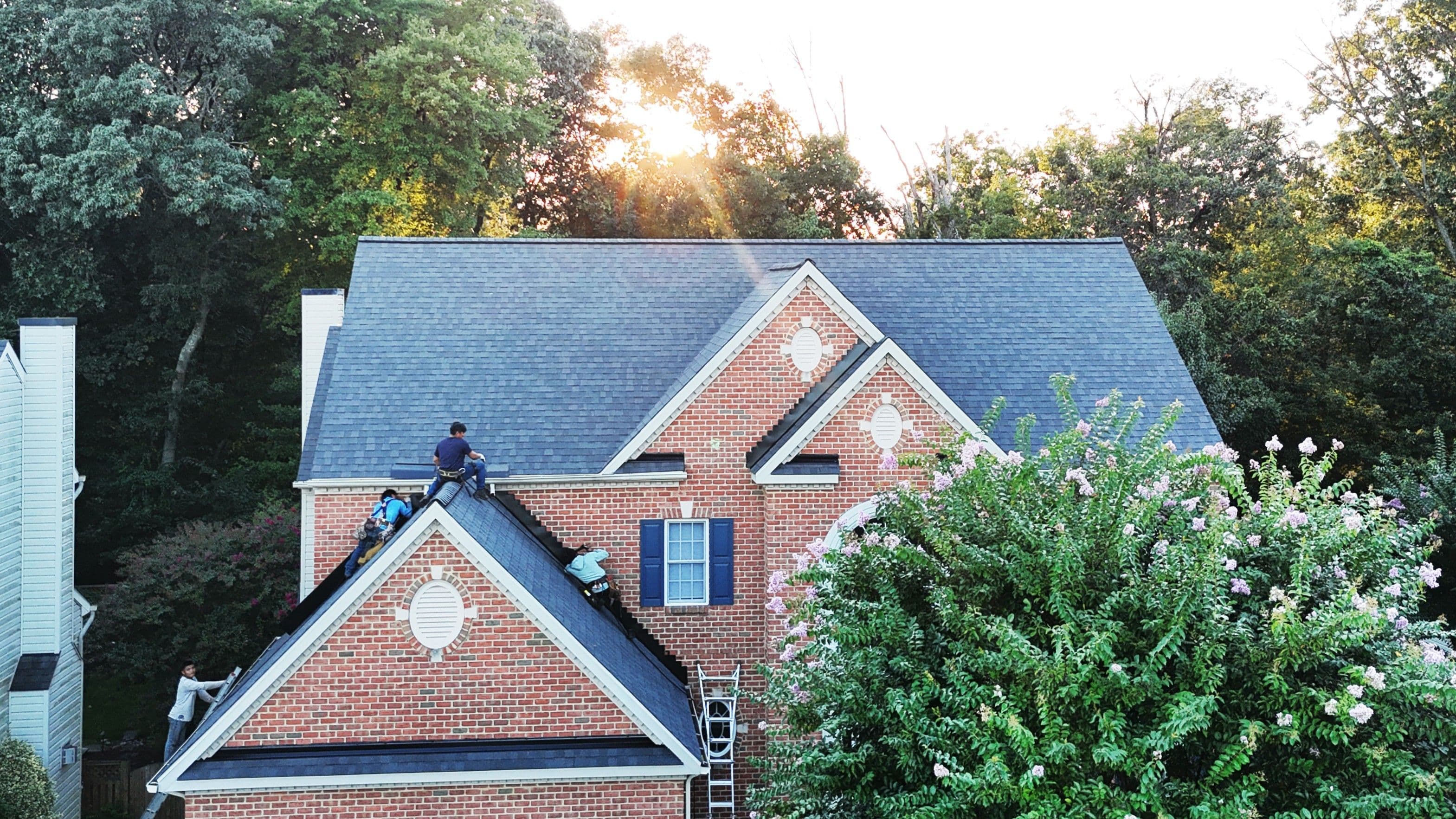Apper Construction family crew installing a new asphalt shingle roof on a brick colonial home in Anne Arundel County, Maryland