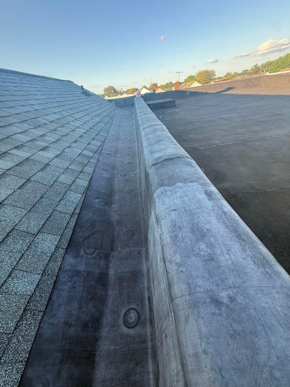 New black EPDM rubber membrane flat roof beside a shingle slope, installed in Maryland by Apper Construction