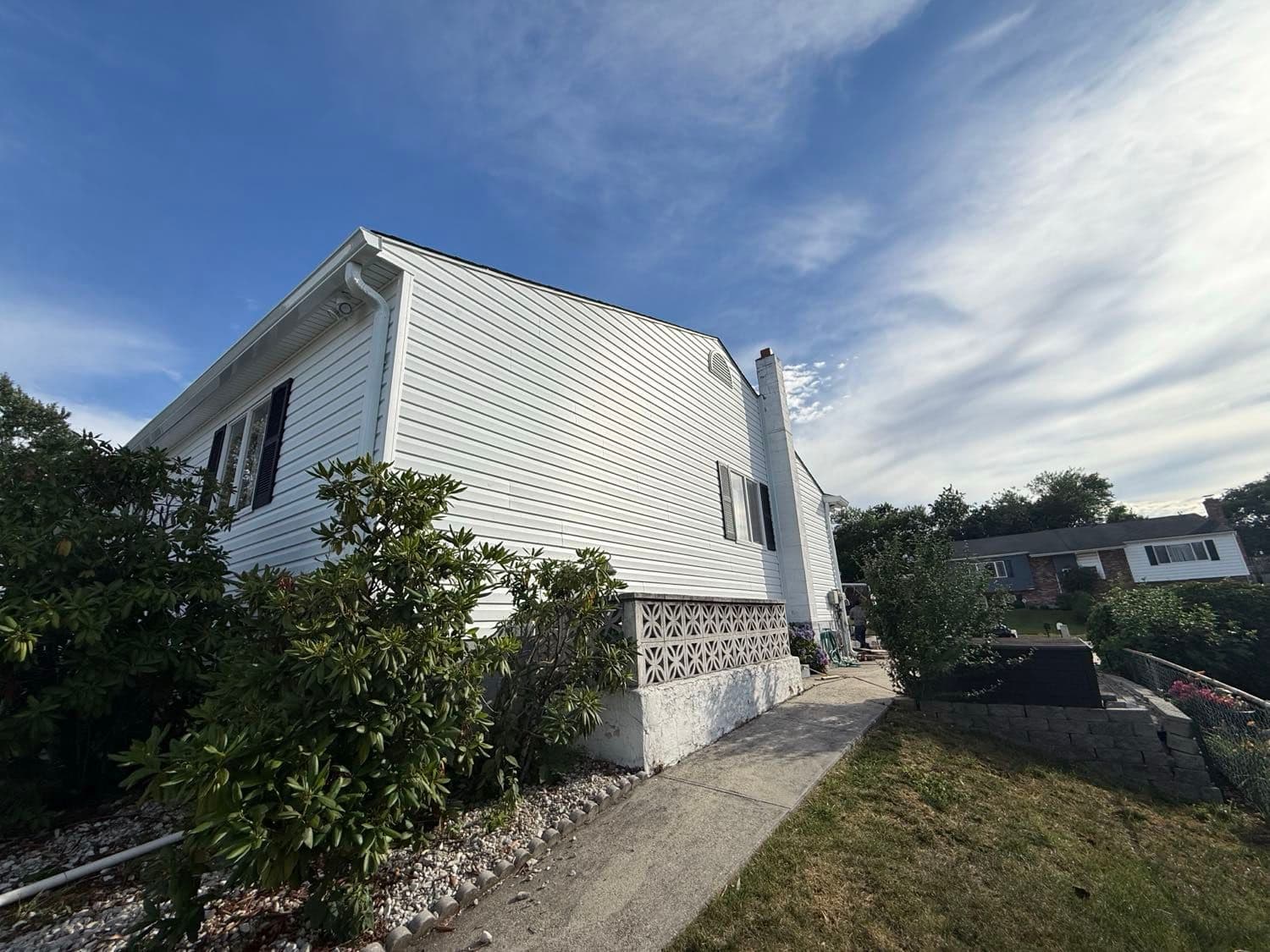 New white Dutchlap vinyl siding, wrapped soffit and a downspout along the side gable of a Pasadena, Maryland home